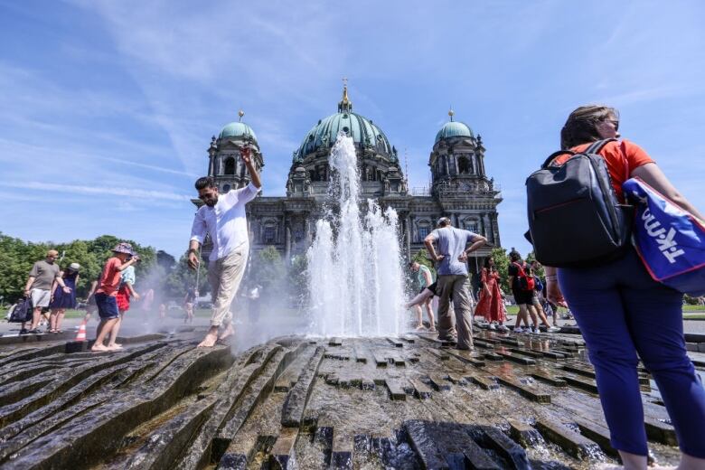 People walk barefoot in a fountain.