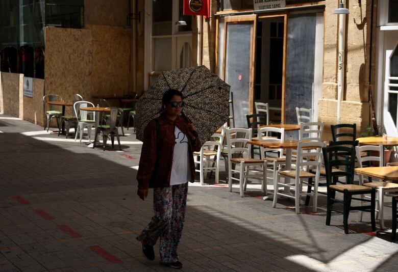 A woman uses an umbrella to shelter from the sun in Nicosia, Cyprus.