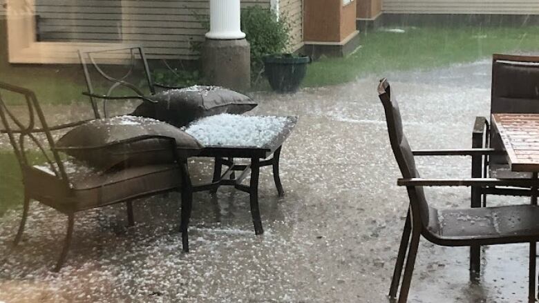 A patio flooded with hail and rain is pictured.