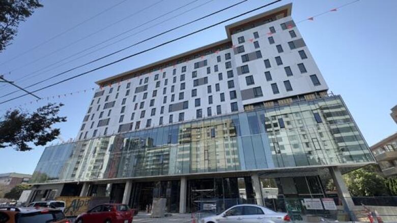 A high-rise building is seen from street level.