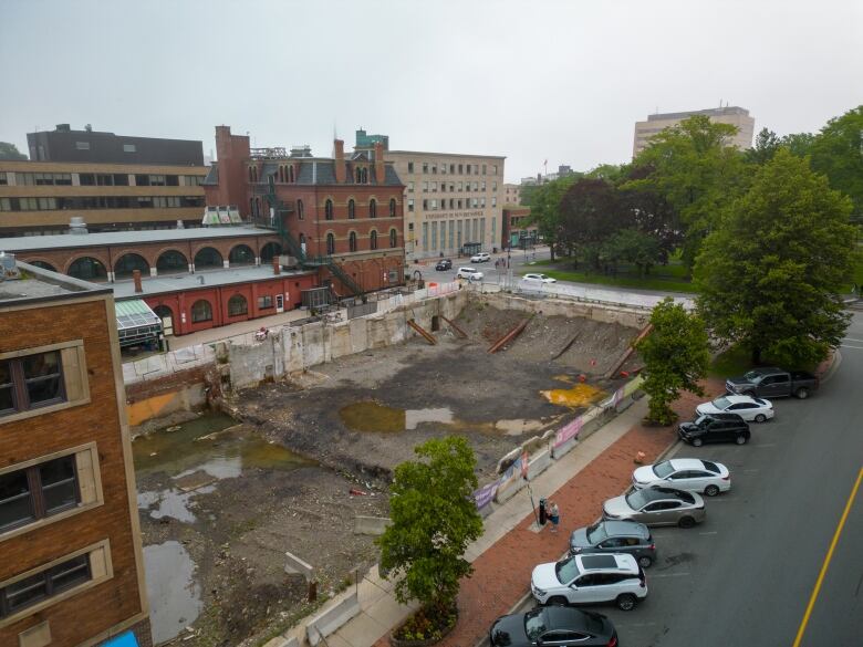 Drone picture of an empty lot with a giant hole in the ground waiting for construction. 