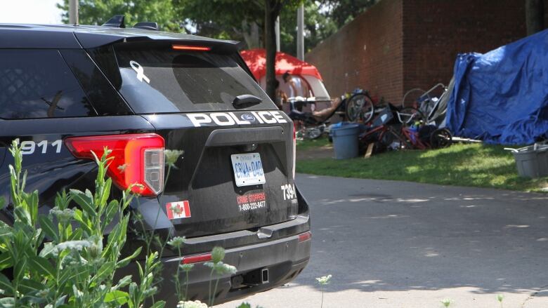 Police car with tents in background