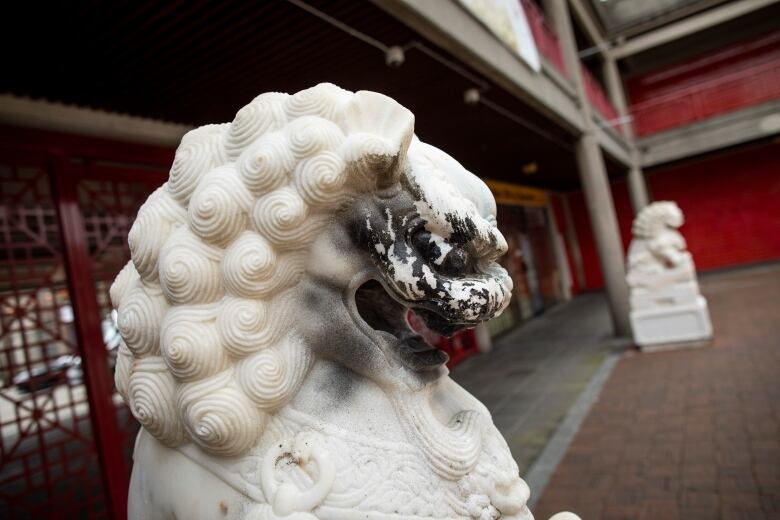 A lion at the gate of Vancouver's chinatown is spray painted black