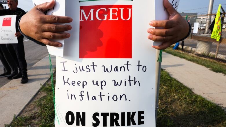 Close up of a striker's hands and sign, which says 