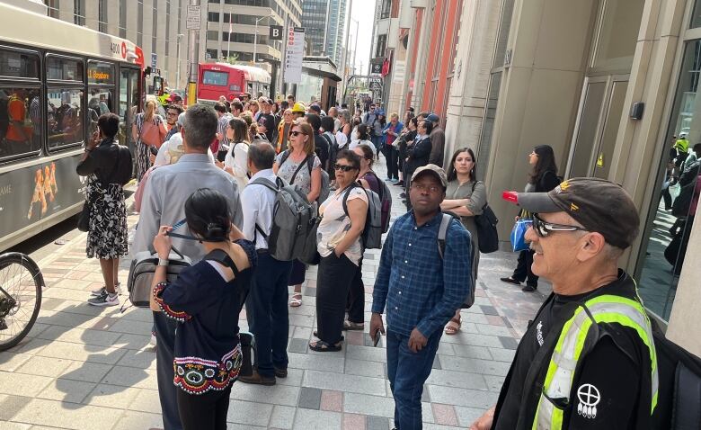 A crowd of people on a downtown city street.