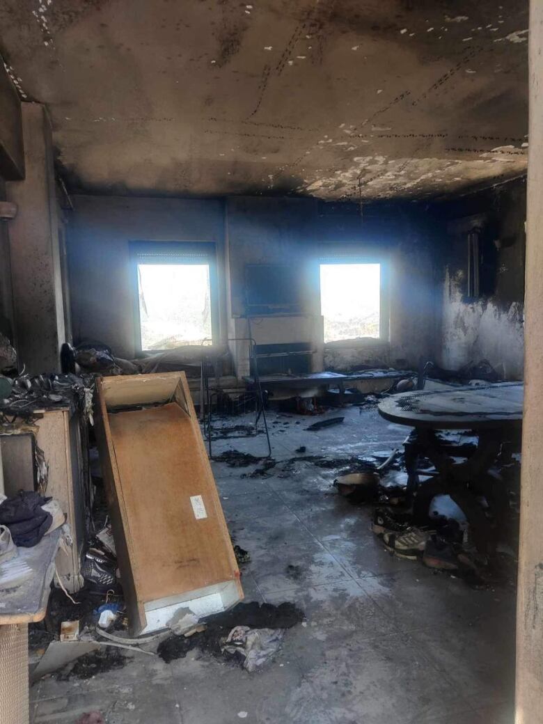 The inside of a home, burnt and covered in black ashes.