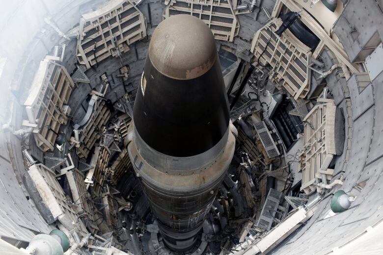 A missile is seen standing in a silo. 