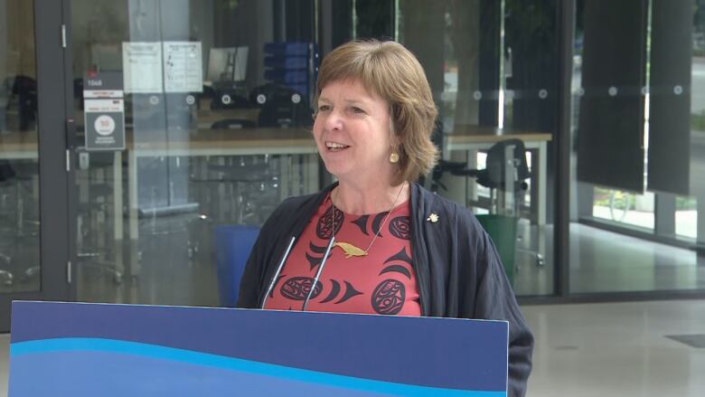 A woman standing behind a podium and giving a speech