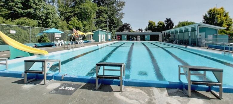 An empty outdoor pool shimmers in the sunshine.