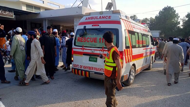 An ambulance arrives to pick up injured people.