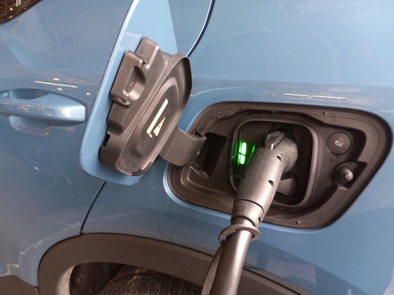 A car being charged through a plug.