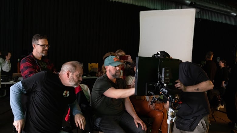 People looking at a camera during a film shoot. 