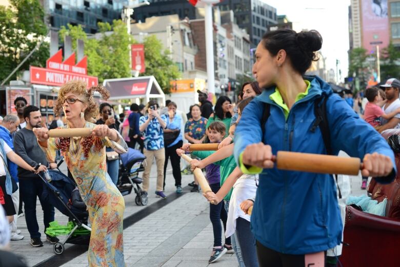 A crowd watches people with rolling pins doing an activity at the Just for Laughs festival.