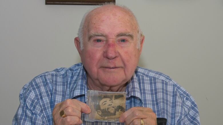 A man holds up a photo.