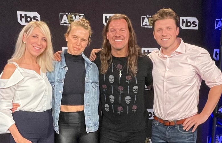 Martha Hart, left, head of the Owen Hart Foundation, poses with her children and pro wrestler Chris Jericho, second from right, at a recent AEW event.