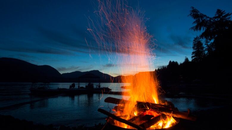 A bonfire in front of a lake