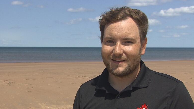 A man stands on the beach. 