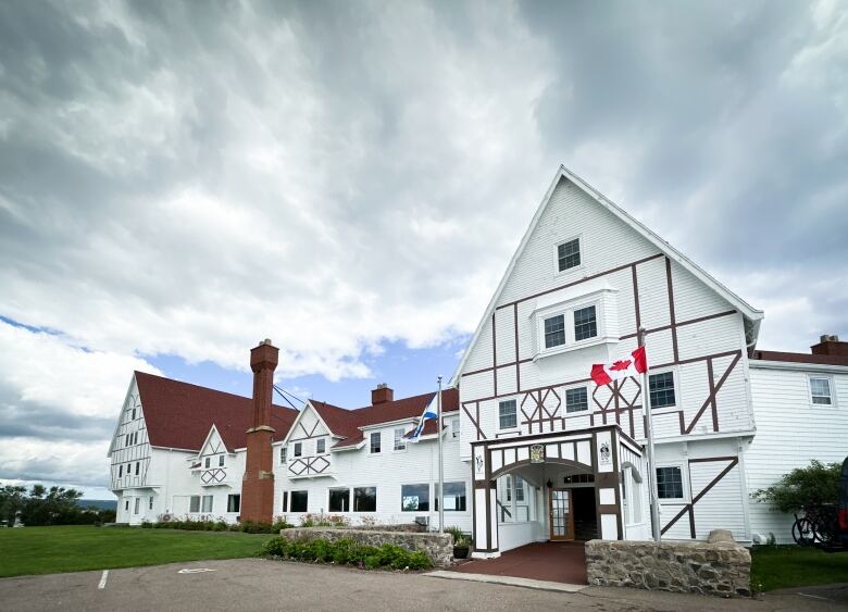 The white facade of an older resort building is shown.