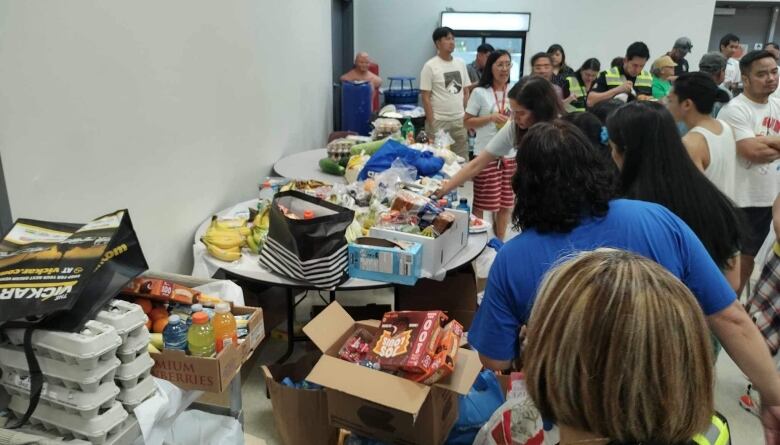 Volunteers organize boxes of food.