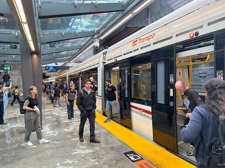 People stand on a train platform.