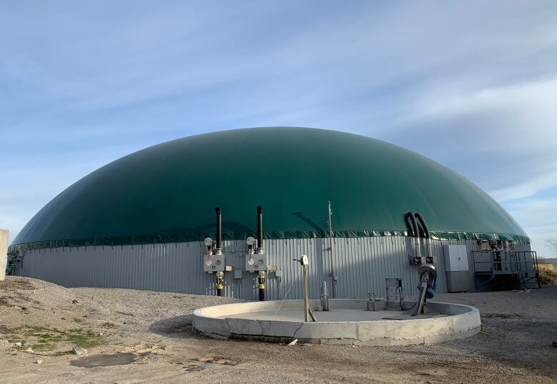 A large, outdoor, metal structure with a green dome on top. 