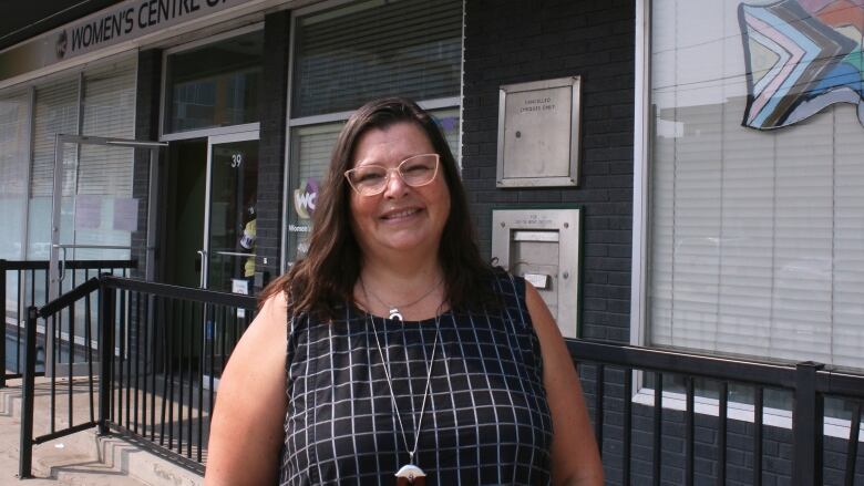 The federal housing advocate smiles in front of the Women's Centre of Calgary's front doors.