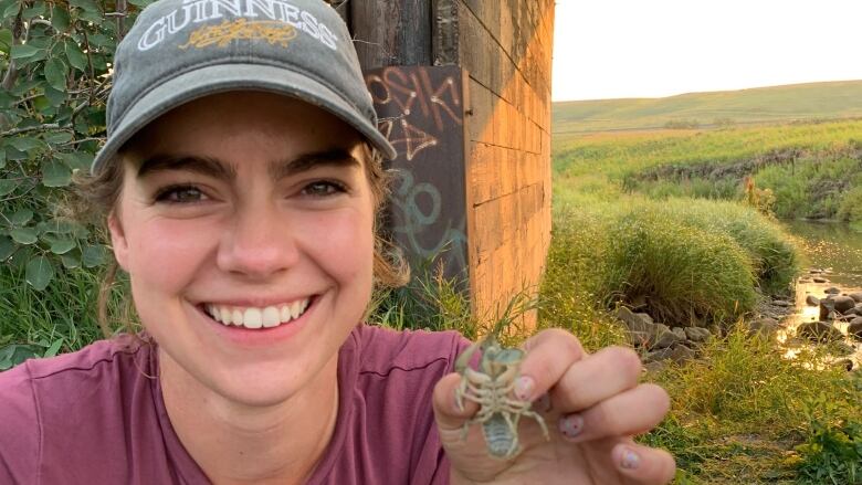 A woman holding up a crayfish