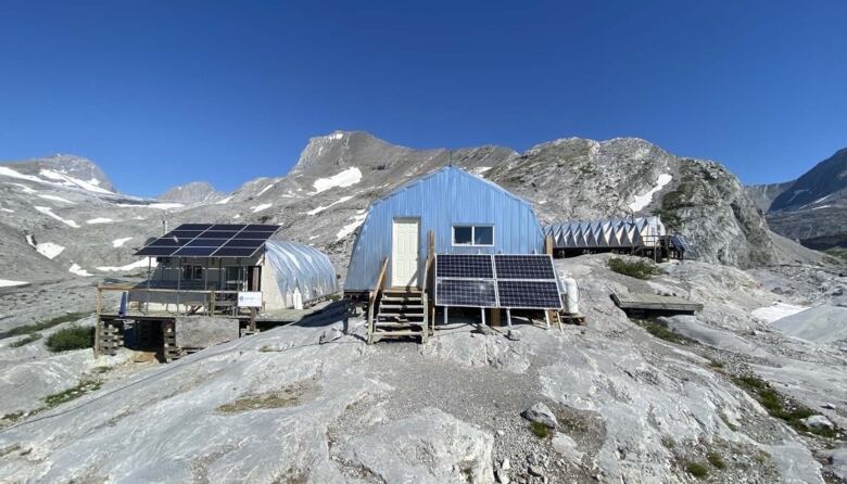 A steel building sits in front of a mountain. 