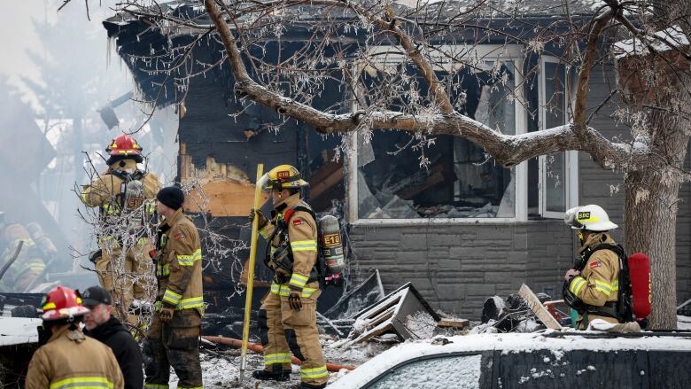 Firefighters attend the scene of a house explosion that injured several people, destroyed one home and damaged others in Calgary on March 27, 2023. Nearly four months after a house explosion sent 10 members of Calgary's South Sudanese community to hospital many of the victims are still struggling but are preparing to give a prayer of thanks for their survival. The blast in late March saw many of those injured blown into the air before falling into a fiery basement below.