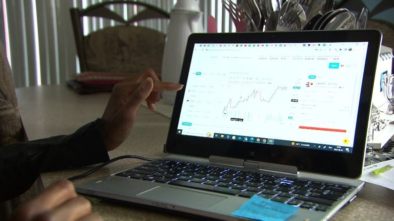 a woman points to a graph on her screen