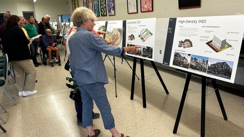 People looking at renders of the proposed plan.