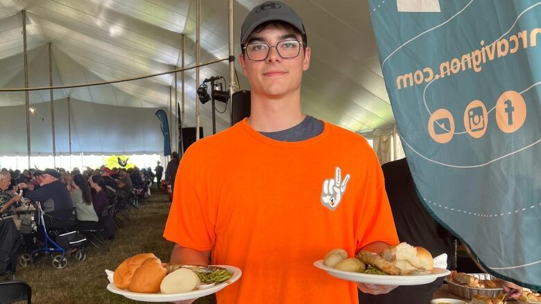 A man holds plates of food.