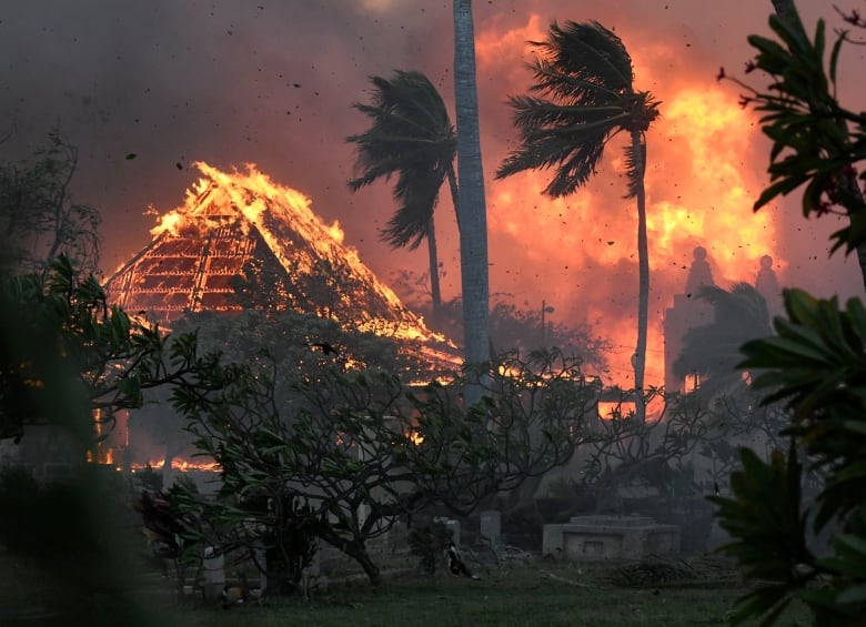 The roof of a building is seen engulfed in flames.