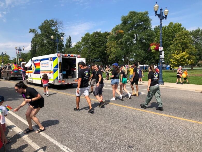 Paramedics and an ambulance marching in a pride parade