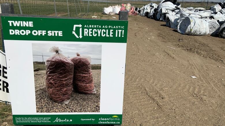 A sign that indicates a drop-off location for baling twine in Alberta. Grain bags are also visible in the background.