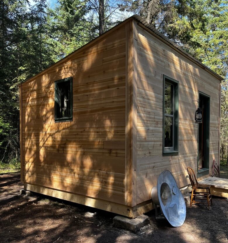 A wooden shed in an outdoor treed area