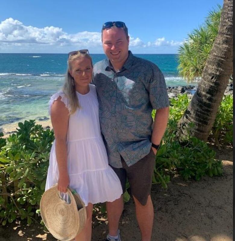 A couple near a palm tree in Hawaii.