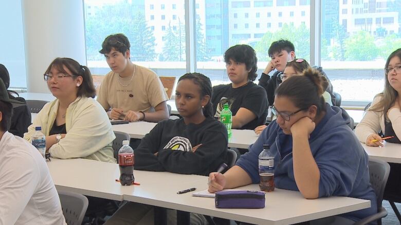 Nine students sitting together in a classroom