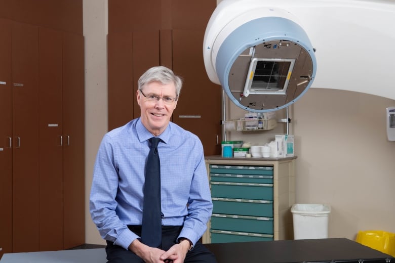 A man sits in front of a medical machine. 