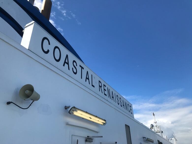 A large white ferry with the words 'Coastal Renaissance' written in blue on the site. 