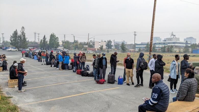 People line up in a parking lot.