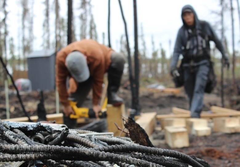 Two men rebuilding after a wildfire