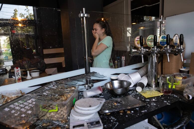 An employee at a cafe in Chernihiv, Ukraine, reacts to the damage caused by a deadly Russian missile attack, in the centre of the city on Saturday.