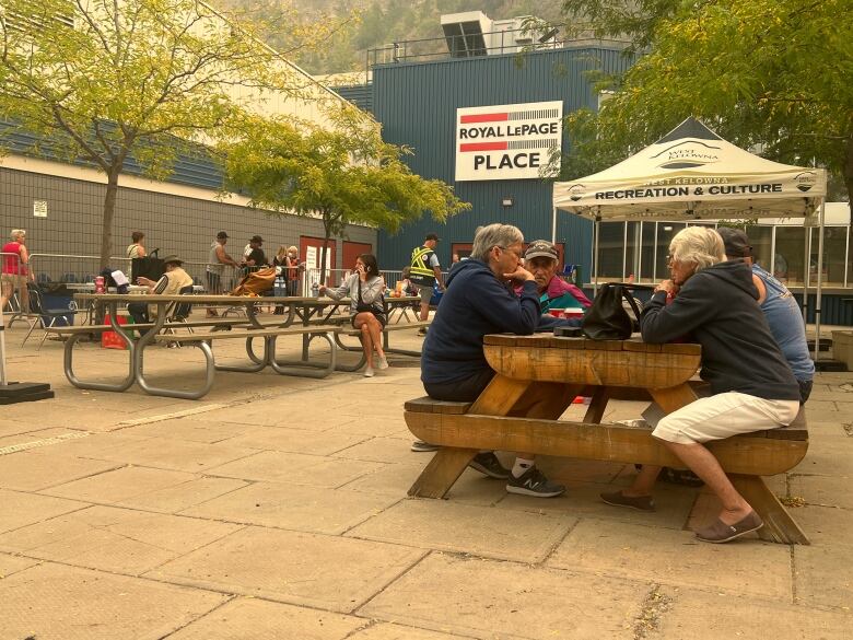 People sit at tables outside.