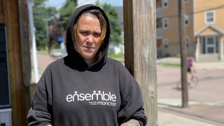 woman in hoodie standing outside on porch