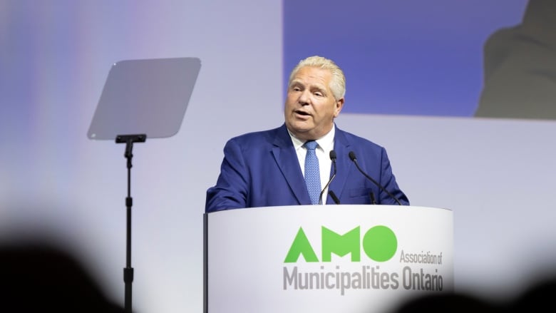 Premier Ford speaks on stage behind a lectern.