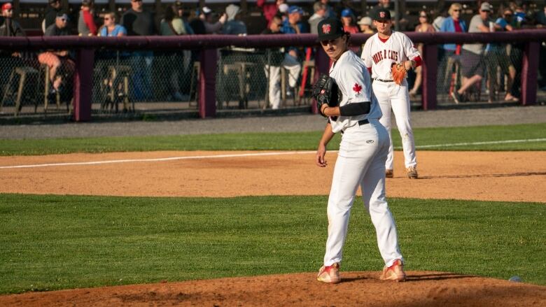 A baseball player looks over his shoulder. 