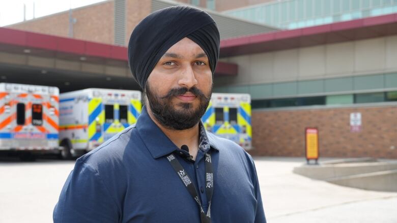 A man stands in front of an ambulance bay