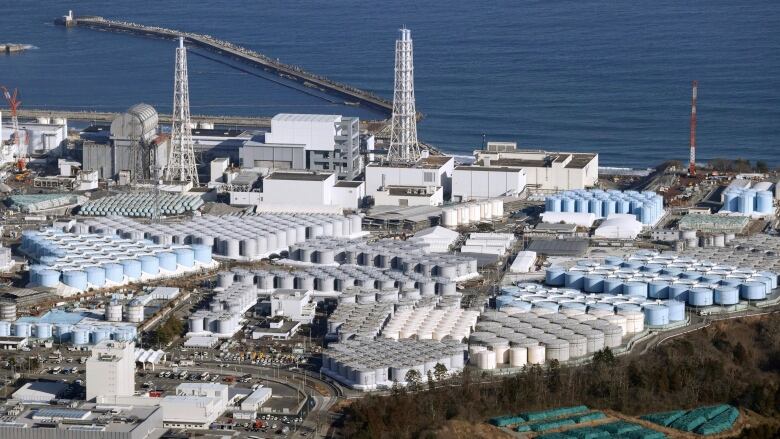 An aerial image of a nuclear power facility along the coast of the ocean. 