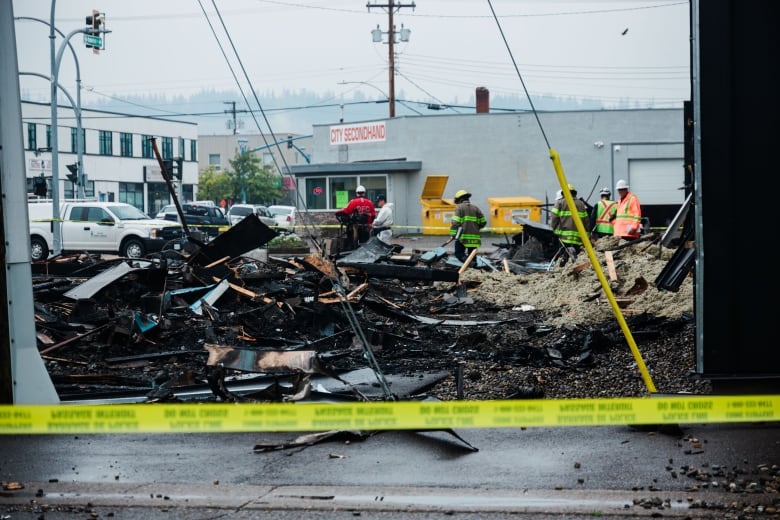 Crews sift through rubble in the aftermath of an explosion and fire.